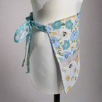 Floral apron on a mannequin against a plain background