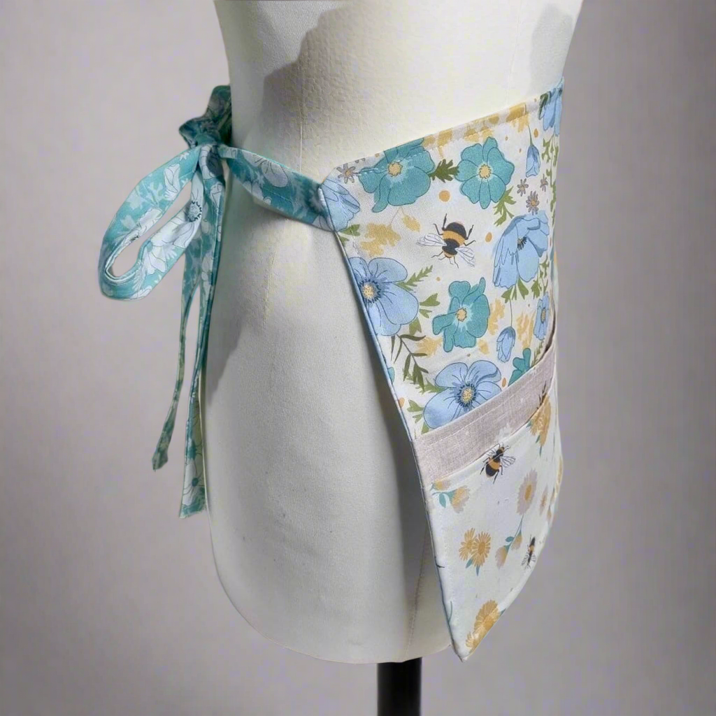 Floral apron on a mannequin against a plain background